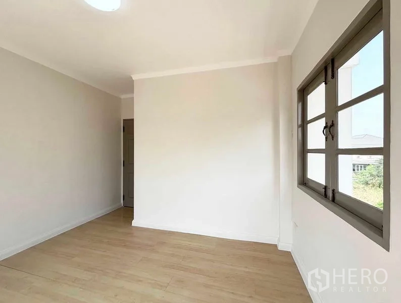 Detached House for rent or sale - Corner bedroom with wood floor and wide window frames.