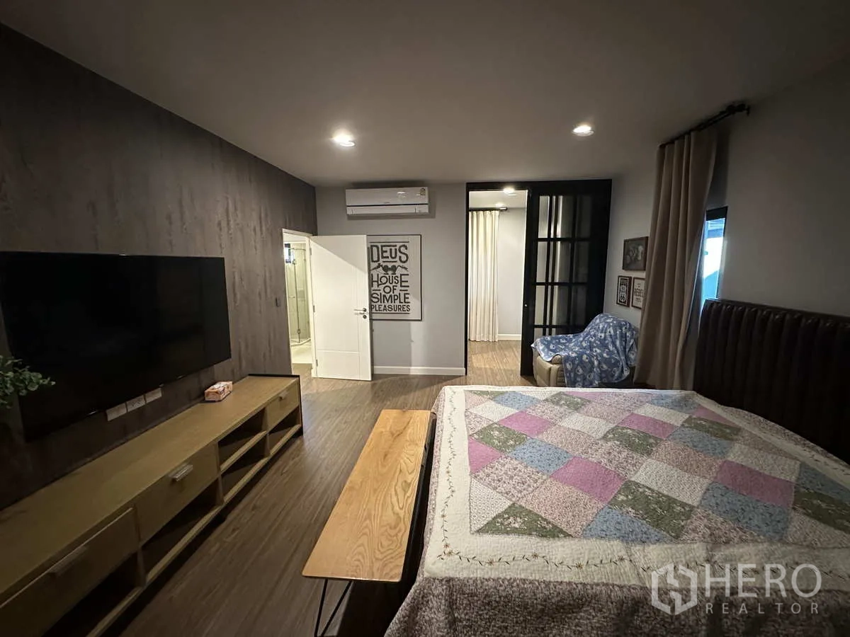 บ้าน ให้เช่าหรือขายในLam Luk Ka, Pathum Thani - ห้องมาสเตอร์มองไปยังตู้เสื้อผ้าและห้องน้ำในตัว พร้อมชั้นวางทีวี.