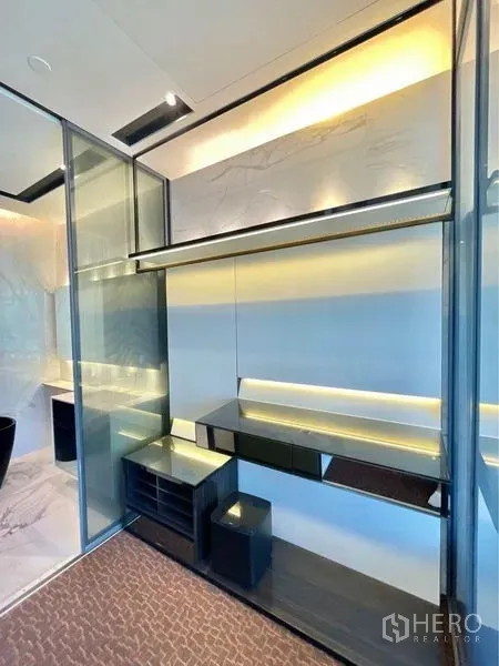 Condominium for rent in Watthana, Bangkok - Glass-partitioned dressing area with built-in shelves and warm LED accent lighting.