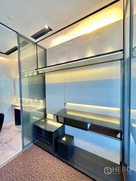 Condominium for rent in Watthana, Bangkok - Glass-partitioned dressing area with built-in shelves and warm LED accent lighting.