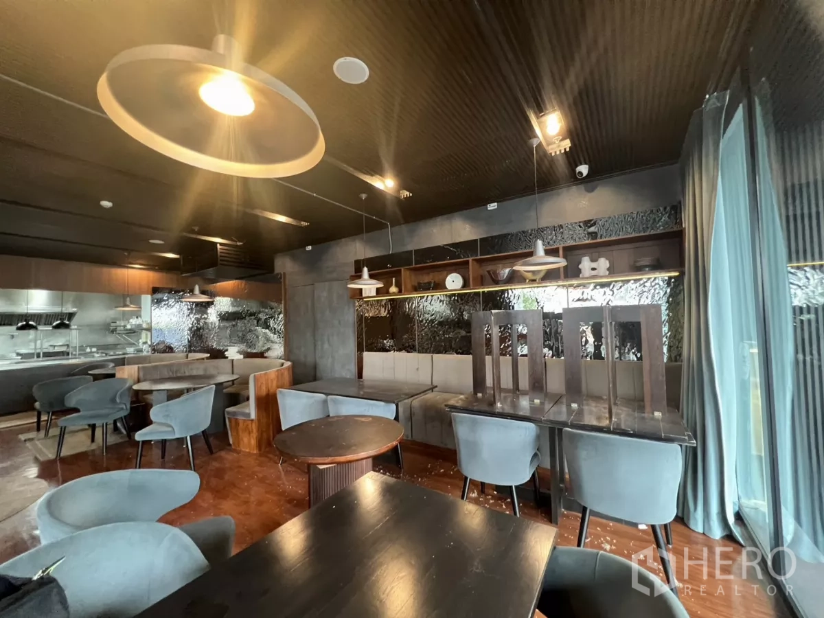 Retail Space for rent - Cozy booths and marble tables in a dark-toned dining space with pendant lights.