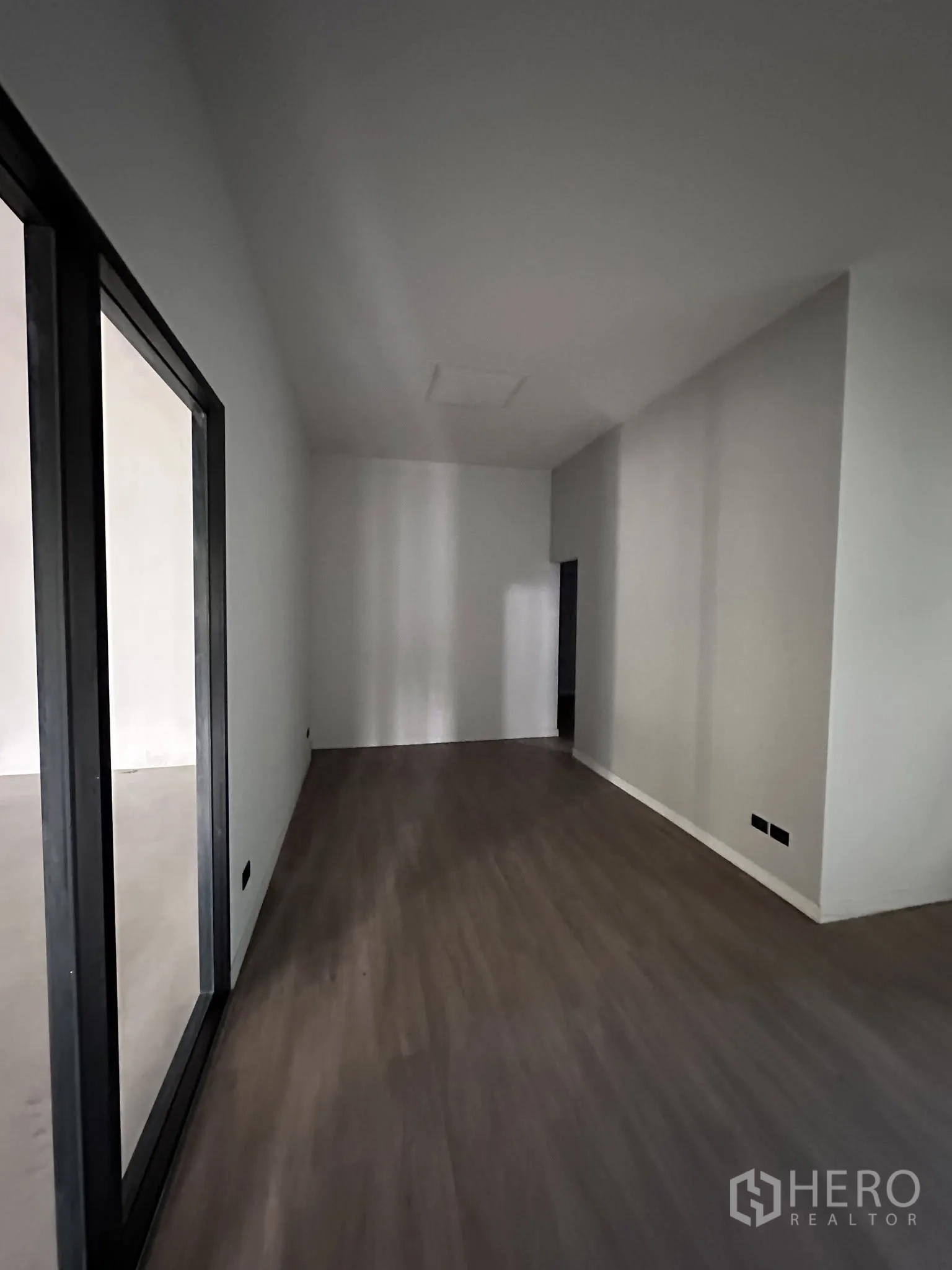 Warehouse for rent or sale in Prawet, Bangkok - Office corridor with wood-look flooring beside glass walls.