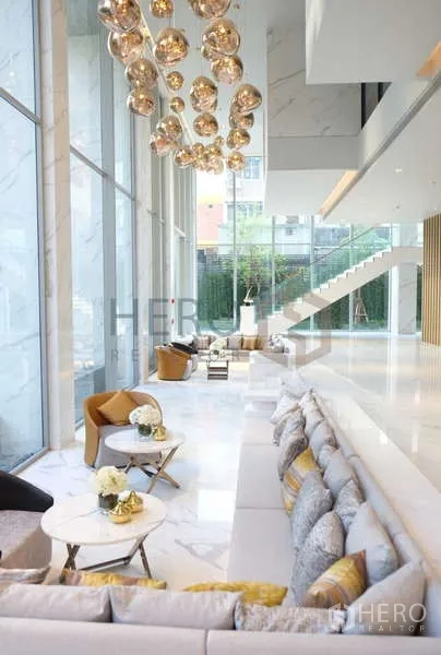 คอนโด ให้เช่า - พื้นที่ต้อนรับสไตล์ทันสมัย โซฟายาวและโคมทองตกแต่ง