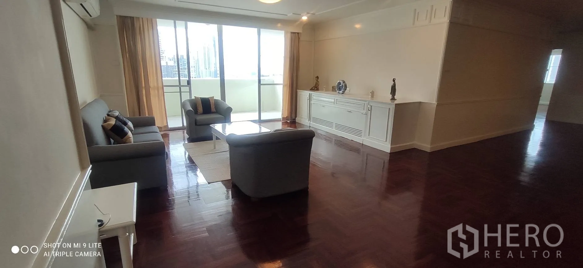 อพาร์ทเมนท์ ให้เช่าในWatthana, Bangkok - ห้องนั่งเล่นกว้าง ชุดโซฟา และประตูกระจกบานเลื่อนเปิดสู่ระเบียงมองเห็นวิวเมือง