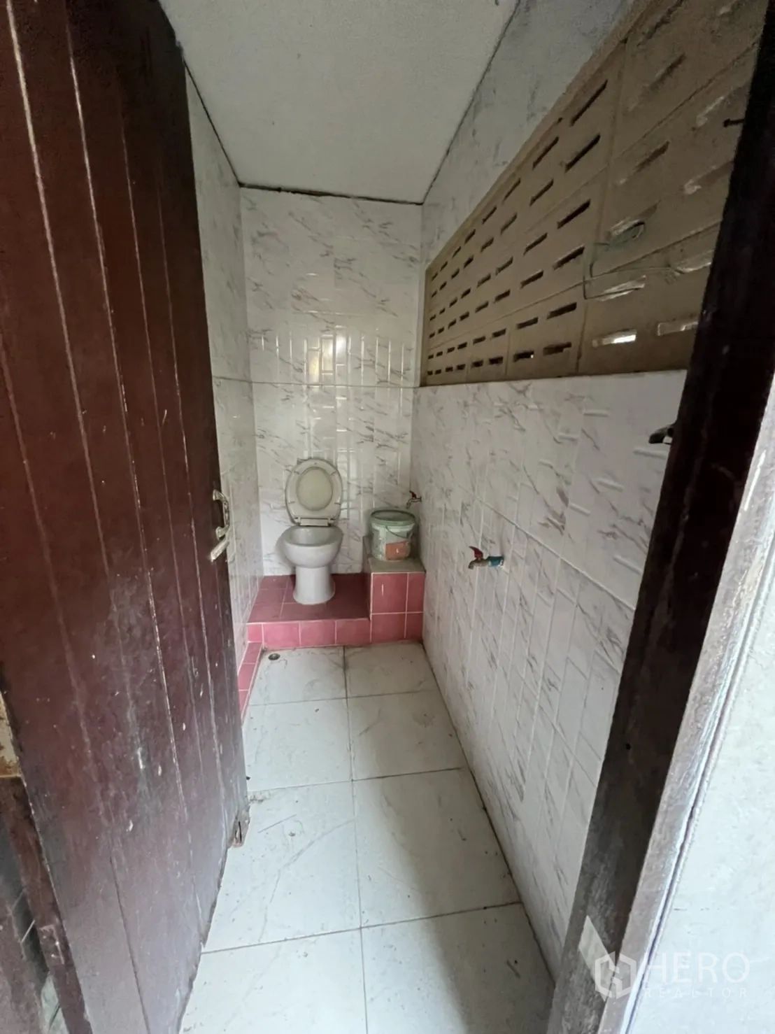Home Office for rent in Watthana, Bangkok - Small restroom with toilet and white wall tiles.