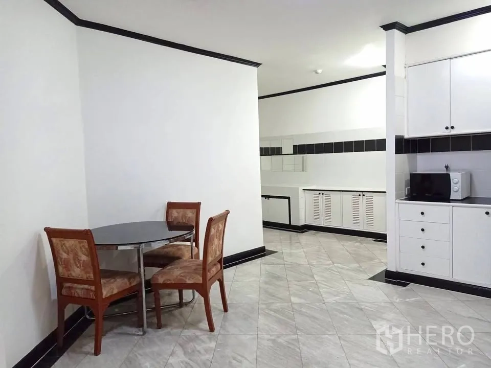 คอนโด for rent in Watthana, Bangkok - มุมรับประทานอาหารกะทัดรัดเก้าอี้สามตัว ติดกับห้องครัวโทนขาว