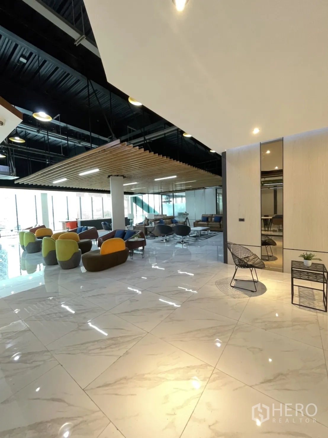 สำนักงาน ให้เช่าในLam Luk Ka, Pathum Thani - พื้นที่ส่วนกลางสว่างไสว เก้าอี้หลากสี เพดานสูงลายไม้ระแนง