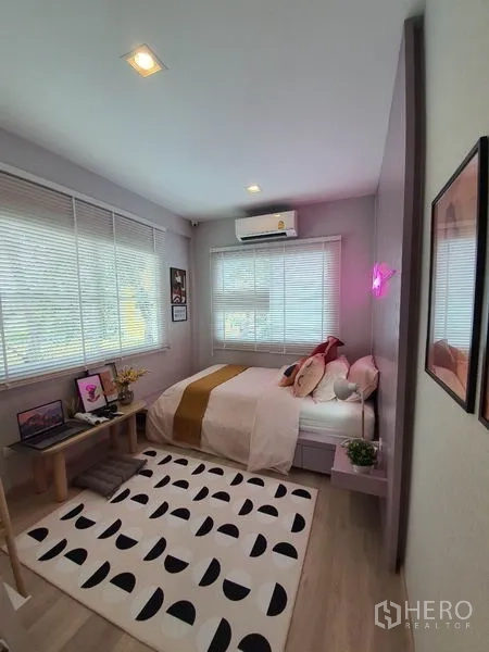 Detached House for rent in Prawet, Bangkok - Cozy bedroom with large windows, blinds, air conditioner and patterned rug.