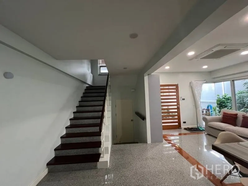 ทาวน์เฮาส์ ให้เช่าในKhlong Toei, Bangkok - ชั้นล่างทางเข้ามีบันไดและโถงรับแขก เปิดมุมมองสู่สวนผ่านประตูกระจก