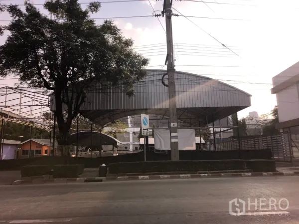 พื้นที่ขายปลีก ให้เช่าในHuai Khwang, Bangkok - คอมพาวด์เชิงพาณิชย์หน้าถนน มีโถงหลังคาเหล็กขนาดใหญ่และต้นไม้ใหญ่ ในย่านห้วยขวาง กรุงเทพฯ