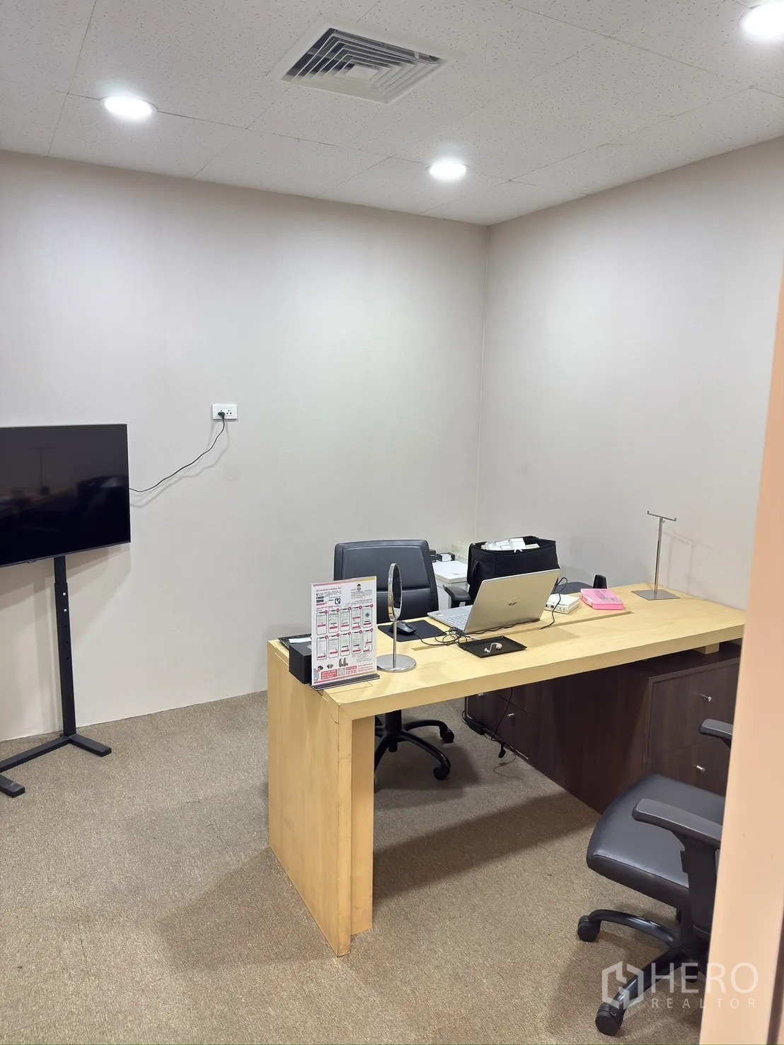 Retail Space for rent in Khlong Toei, Bangkok - Private office room with wooden desk, rolling chairs, carpeted floor, and TV on a stand.