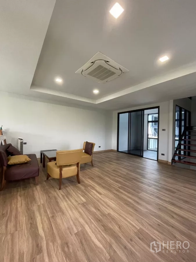 Home Office for rent in Khan Na Yao, Bangkok - Upper-floor lounge with wood flooring, cassette ceiling air-conditioner and sliding glass doors.