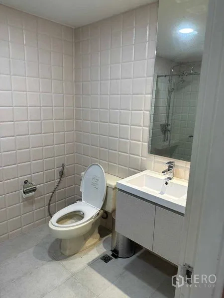 คอนโด ให้เช่าหรือขายในBangkok - ห้องน้ำพร้อมอ่างล้างหน้าแบบตู้ โถสุขภัณฑ์ และผนังกระเบื้อง