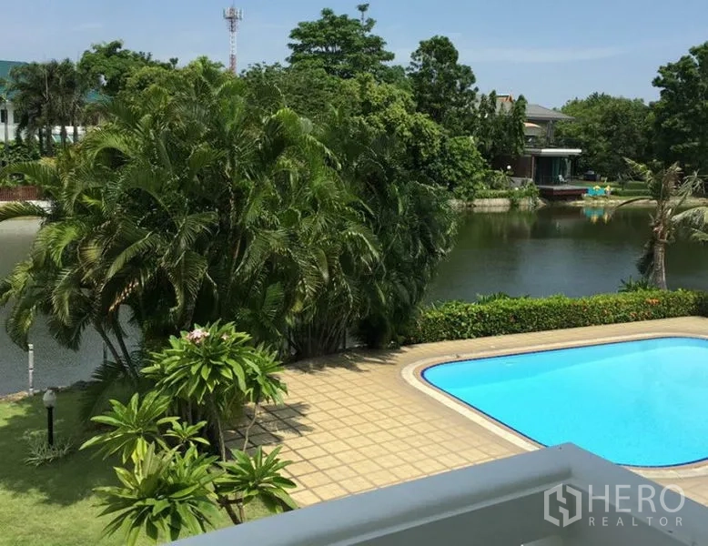 独立式住宅 出租在Bang Phli, Samut Prakan - 阳台视角，面向私人泳池、棕榈树与静谧湖景。