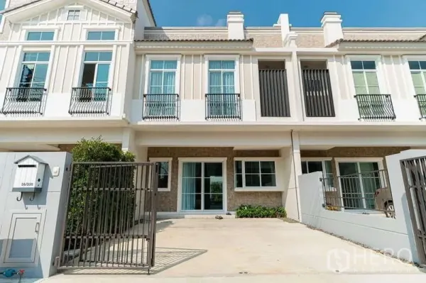 Detached House for rent in Prawet, Bangkok - Modern home facade with gated parking area and tall windows.