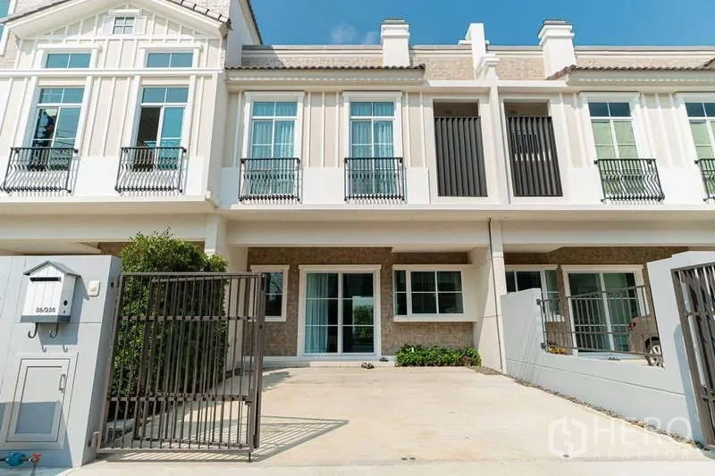 Detached House for rent in Prawet, Bangkok - Modern home facade with gated parking area and tall windows.