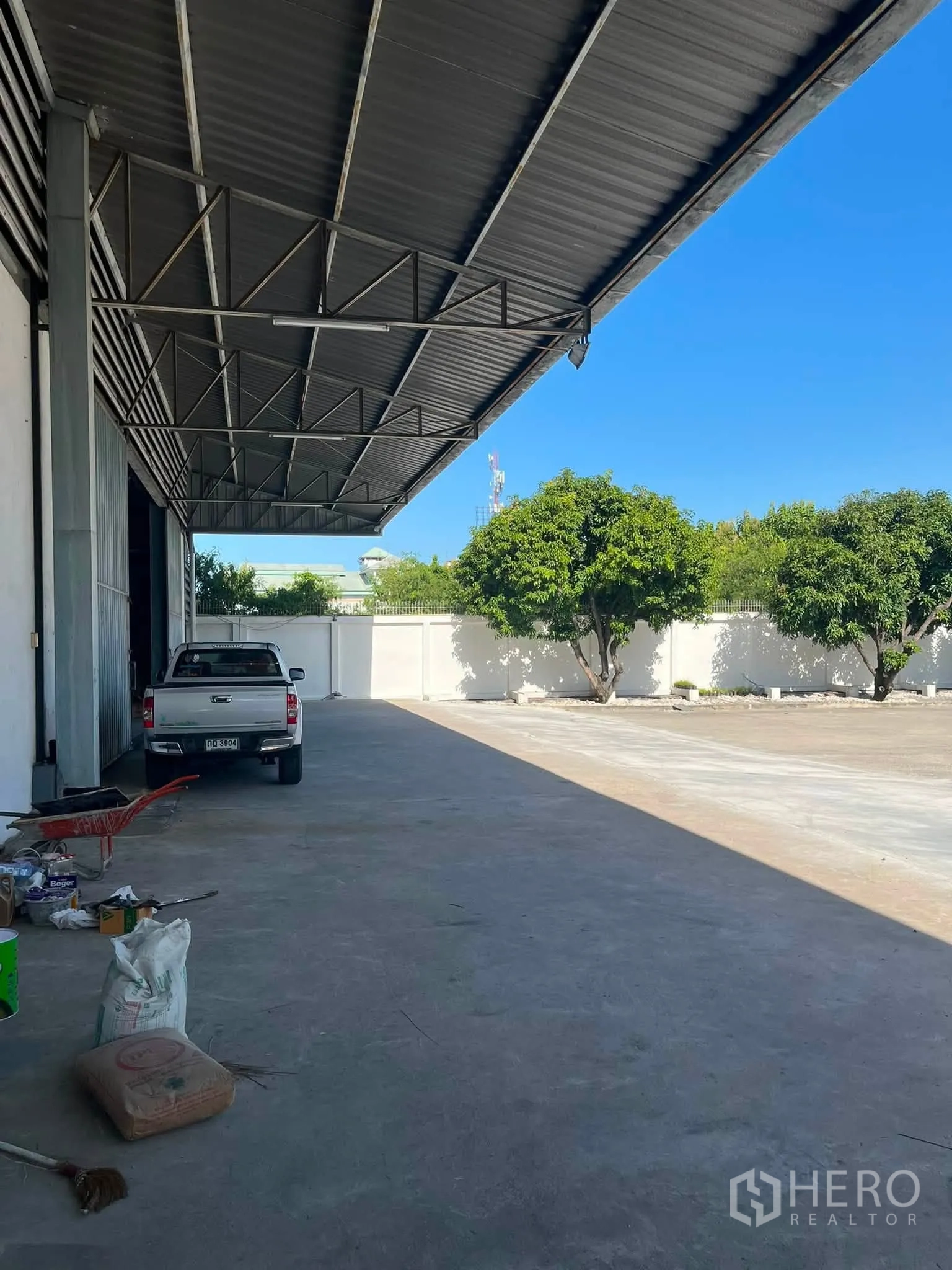 Warehouse for rent in Bang Phli, Samut Prakan - Covered loading area and wide concrete yard alongside the warehouse.