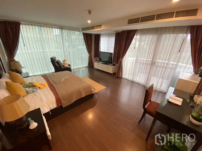 อพาร์ทเมนท์ ให้เช่าในWatthana, Bangkok - ห้องนอนใหญ่กว้าง เตียงคิง เก้าอี้พักผ่อน และม่านสูงจรดเพดาน