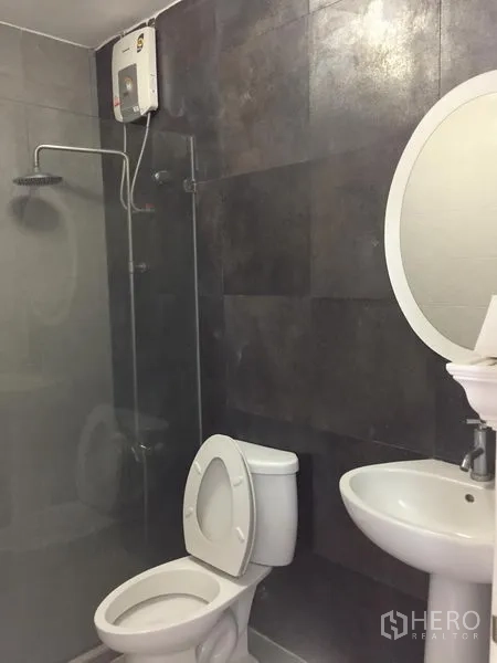 ทาวน์เฮาส์ ให้เช่าในChatuchak, Bangkok - ห้องน้ำปูกระเบื้องสีเข้ม พร้อมฉากกั้นกระจก เรนชาวเวอร์ และเครื่องทำน้ำอุ่น