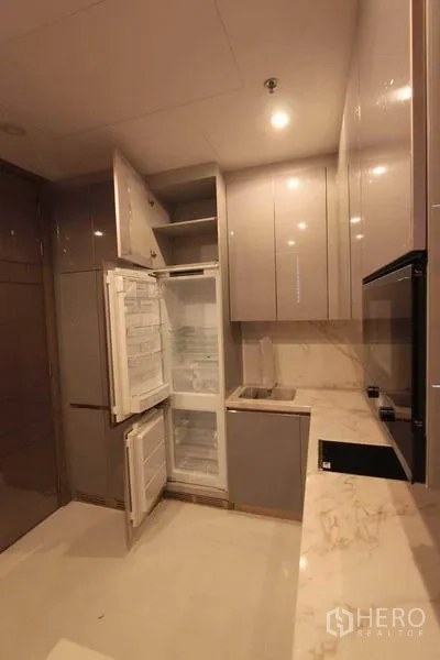 คอนโด ให้เช่าในHuai Khwang, Bangkok - ครัวยุคใหม่ตู้ลอยมันวาว เคาน์เตอร์หินอ่อน ตู้เย็นบิ้วท์อินเปิดอยู่