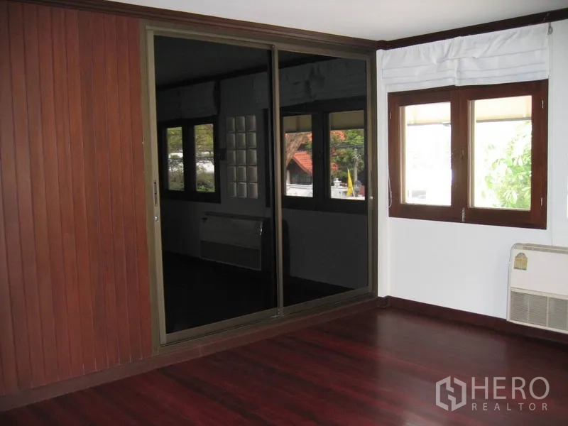 บ้าน ให้เช่าในWatthana, Bangkok - ห้องนอนมีตู้เสื้อผ้าบานกระจกสไลด์ หน้าต่าง และพื้นไม้