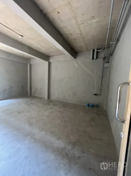 零售空间 出租在Watthana, Bangkok - 从门口望向的店内，水泥地面与机电管线，待二次装修