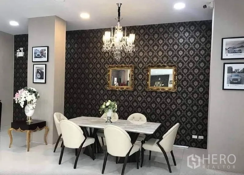 零售空间 出租在Bangkok - 优雅就座区，水晶吊灯、石材餐桌与花纹背景墙，适合咖啡馆或会客区。