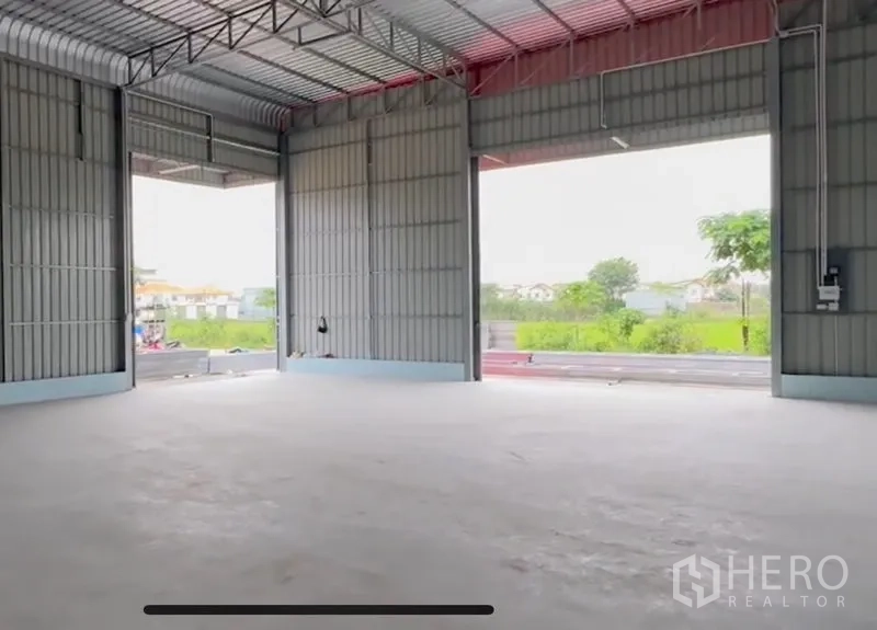 คลังสินค้า ให้เช่าในLam Luk Ka, Pathum Thani - ภายในโกดังโปร่ง เพดานสูงโครงเหล็ก ช่องเปิดกว้าง และพื้นคอนกรีตเรียบ มองเห็นพื้นที่สีเขียว