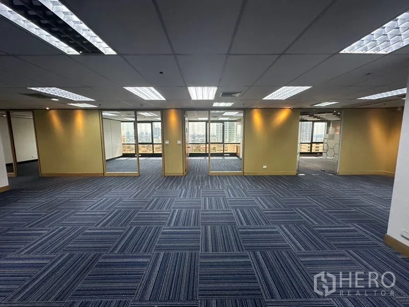 Office Space for rent in Khlong Toei, Bangkok - Large workspace with blue carpet tiles and multiple glass doors to offices.