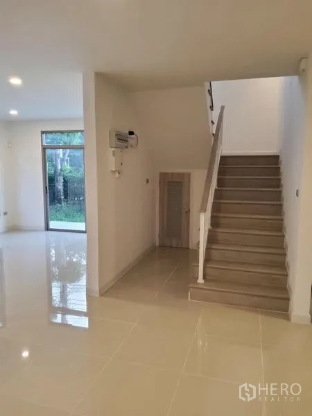 บ้าน ขายในNuea Khlong, Krabi - พื้นที่ชั้นล่างแบบเปิดโล่ง พร้อมบันไดและช่องเก็บของใต้บันได มองเห็นสวนผ่านกระจกบานเลื่อน