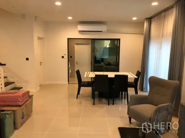 Detached House for rent or sale in Bang Kapi, Bangkok - Open dining area with six-seat table, stairway and sliding door leading to the closed kitchen.