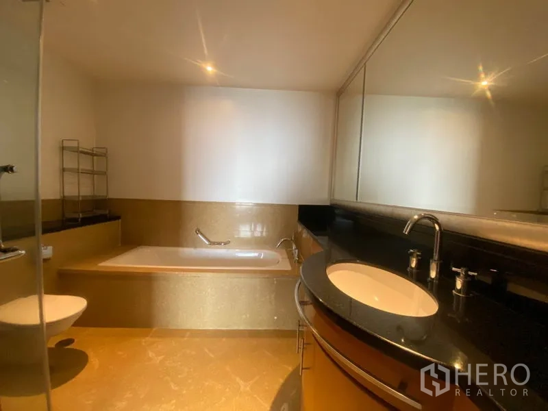 公寓 出租在Sathon, Bangkok - 主卫设宽大台面与大镜子，浸泡浴缸及玻璃淋浴区。