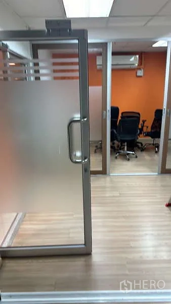 สำนักงาน ให้เช่า - ประตูกระจกฟรอสต์เข้าสู่ห้องประชุม ผนังสีส้มและชุดที่นั่ง