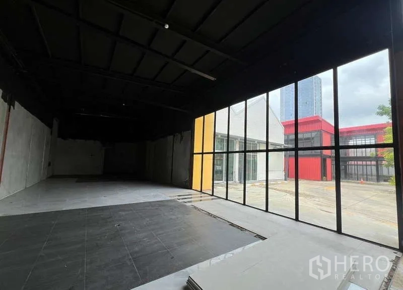 Retail Space for rent in Bang Na, Bangkok - Spacious shop unit with floor-to-ceiling windows overlooking a modern commercial courtyard.