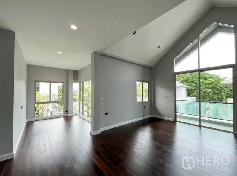 独立式住宅 出租 - 二层房间，挑高斜屋顶与玻璃栏杆阳台。