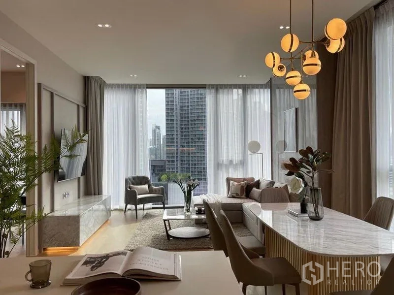 公寓 出租在Watthana, Bangkok - 开放式客餐厅配设计感吊灯与高挑落地窗俯瞰城市。