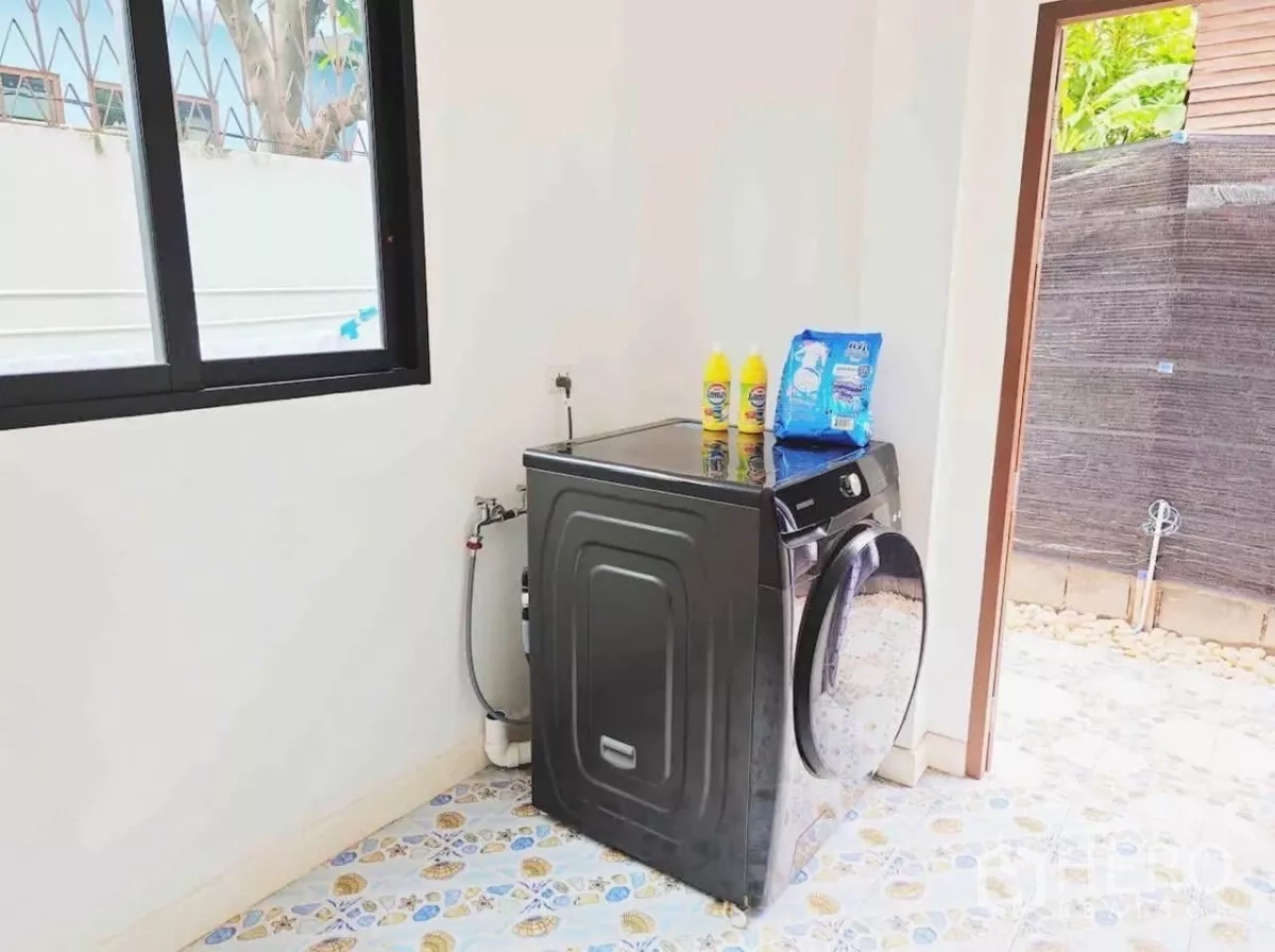 独立式住宅 出租在Phaya Thai, Bangkok - 洗衣区，前开门洗衣机、洗涤槽并通向小庭院。