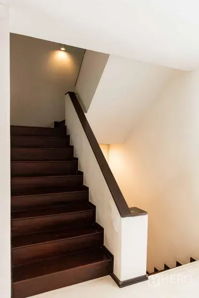 联排别墅 出售 - 楼梯间，深色木踏步与墙面灯光。
