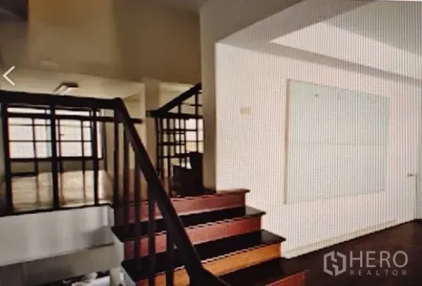 Home Office for rent in Khlong Toei, Bangkok - Wooden staircase with dark handrails leading to bright upper floor with white walls.
