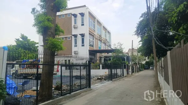 带办公室的家 出租在Wang Thonglang, Bangkok - 现代四层角落楼外观，黑色围栏与侧方停车区
