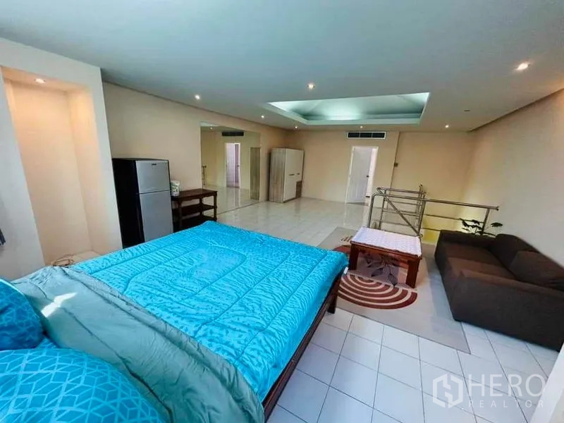 Home Office for rent - Large bedroom level with skylight feature, bed, sofa seating and rail staircase.