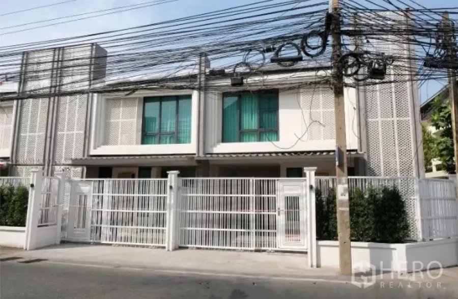 ทาวน์เฮาส์ ให้เช่าในWatthana, Bangkok - ด้านหน้าทาวน์เฮ้าส์สองชั้น รั้วเหล็กสีขาวริมถนนเงียบสงบ