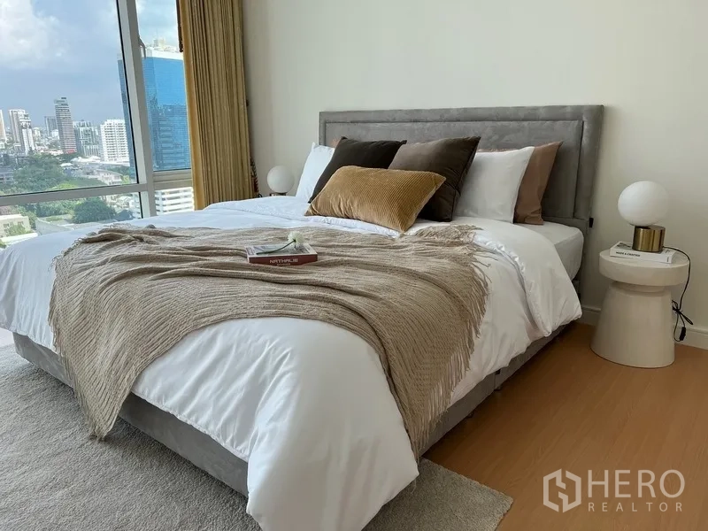 คอนโด ให้เช่าในWatthana, Bangkok - ห้องนอนตกแต่งโทนอุ่น หมอนหลายใบและผ้าคลุมบนเตียง ใกล้หน้าต่างบานใหญ่