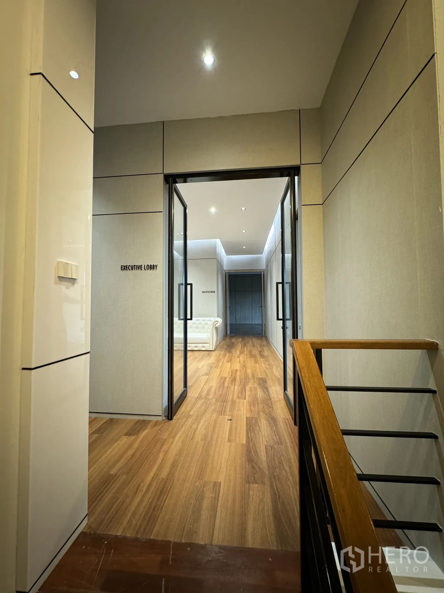Home Office for rent or sale in Bang Phli, Samut Prakan - Corridor to the executive lobby with glass doors and wood flooring.