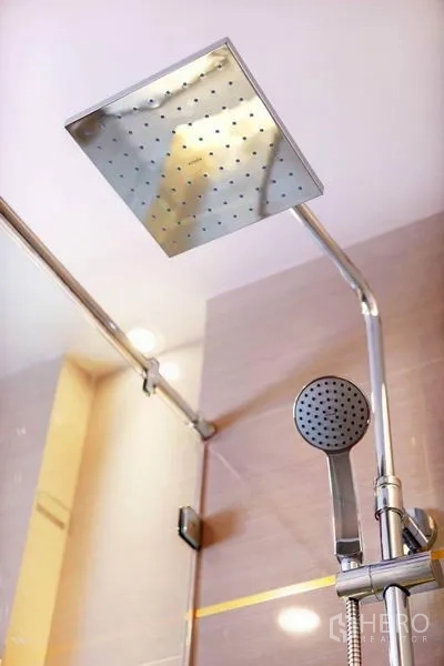 Condominium for rent in Huai Khwang, Bangkok - Rainfall shower head and handheld set inside a glass-enclosed shower.