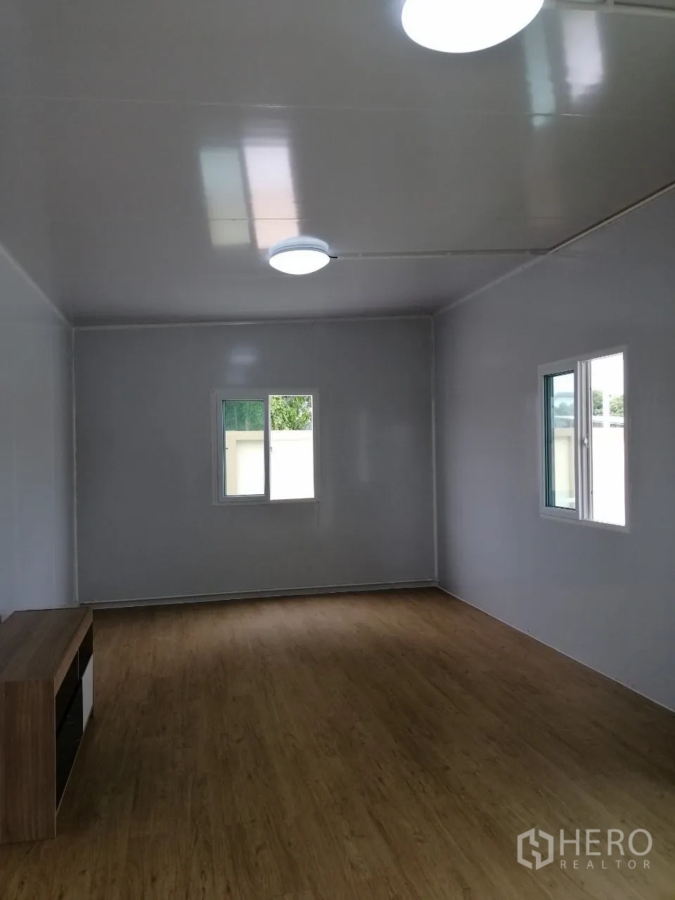Warehouse for rent in Bang Bua Thong, Nonthaburi - Bright office room with wood-look flooring and multiple windows inside the compound.