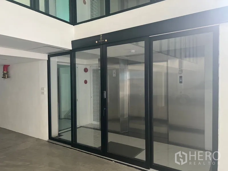 Office Space for rent or sale in Wang Thonglang, Bangkok - Elevator lobby with sliding glass doors and stainless-steel lift.