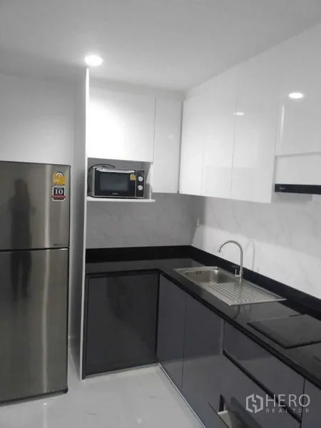 公寓 出租或出售在Khlong Toei, Bangkok - 当代风L形厨房，亮面柜体、水槽与冰箱。