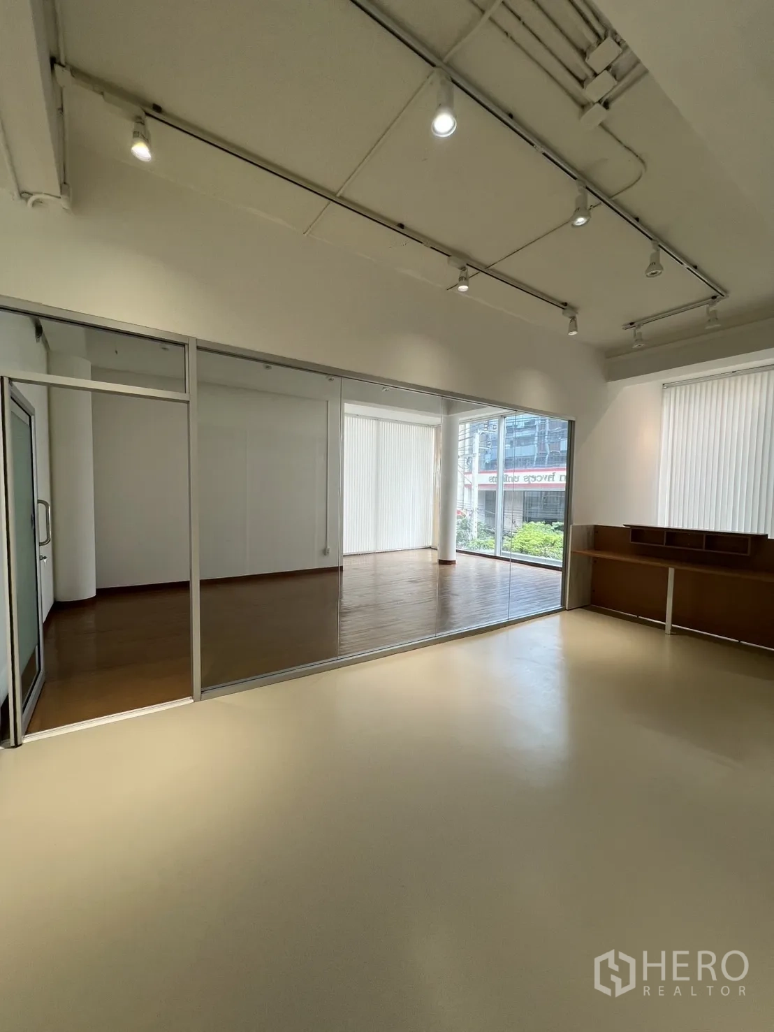 Office Space for rent in Bang Rak, Bangkok - Open office area with large windows, wood flooring and a full-height glass wall.