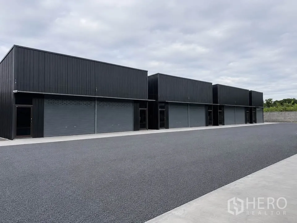 Warehouse for rent in Bang Kapi, Bangkok - Row of modern warehouse units with roll-up doors and ample maneuvering space.